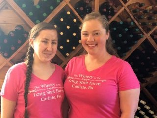 Ladies standing in front of a wine rack