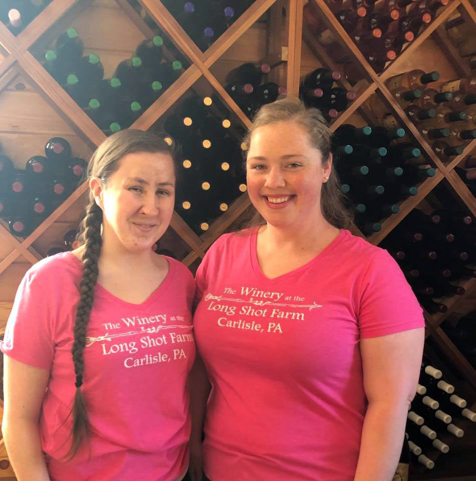 Ladies standing in front of a wine rack